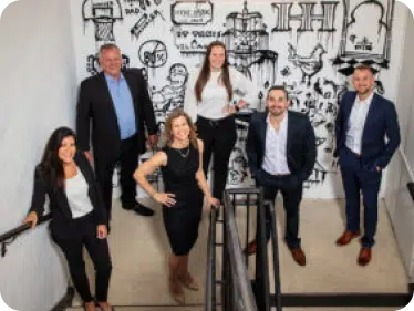 A group of people standing on a staircase landing 